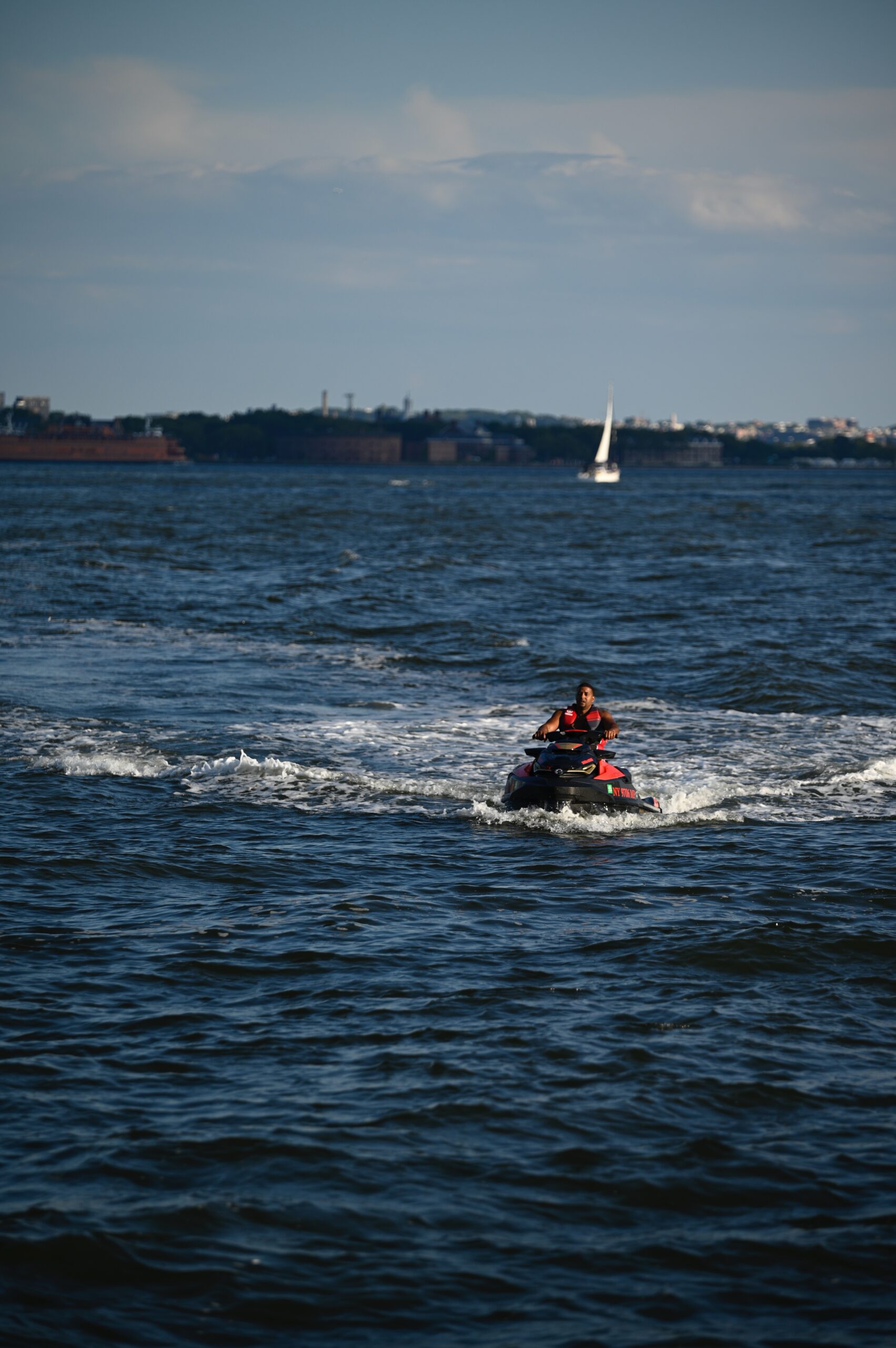 Bilden visar en person som kör vattenskoter ute i skärgården. Vattenskoterregler ställer krav på förarbevis när du ska köra vattenskoter.